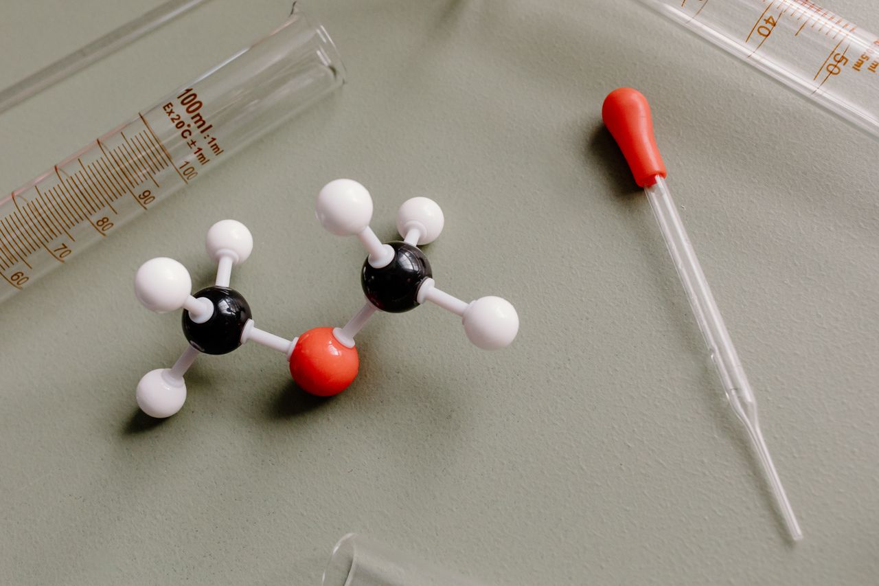 Close-up of laboratory equipment and molecular model on a flat surface.